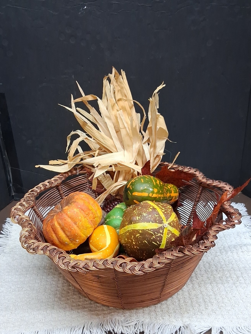 Round coiled copper wire basket featuring a distinctive braided rim detail